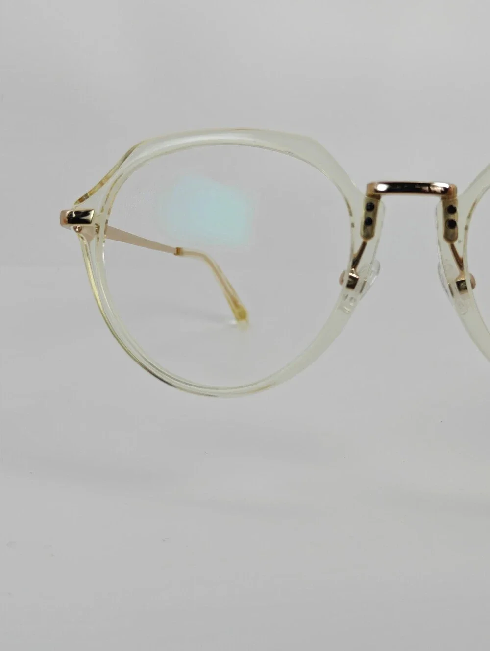 Tamara. Clear Round Frame Glasses. All Gold Accents are Metal.
